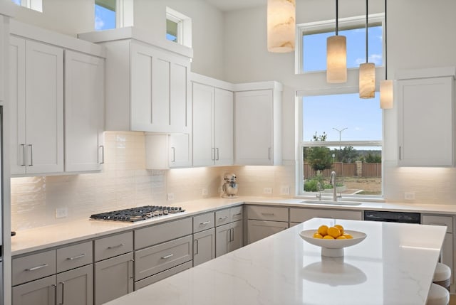 301 Miranda Way, Georgetown, TX 78633 - kitchen featuring stainless steel gas stovetop, backsplash, gray cabinetry, and light stone counters