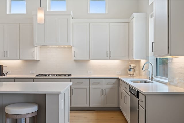 kitchen featuring backsplash, stainless steel appliances, sink, light hardwood / wood-style flooring, and gray cabinets