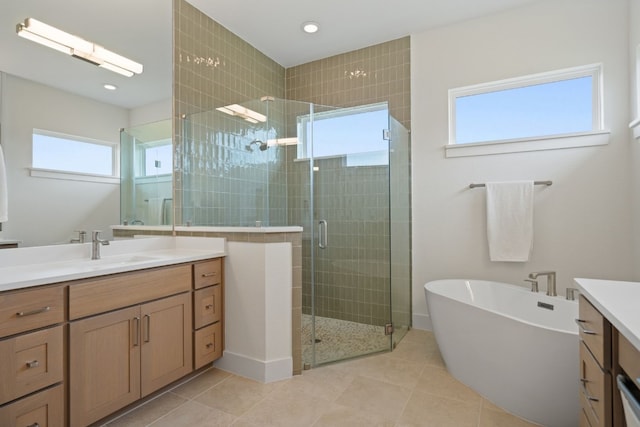 bathroom featuring plus walk in shower, vanity, and tile patterned flooring