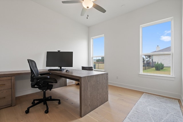 home office featuring ceiling fan, vaulted ceiling, and light hardwood / wood-style flooring