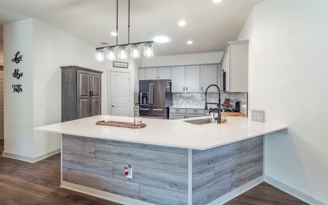 kitchen featuring kitchen peninsula, stainless steel refrigerator with ice dispenser, dark hardwood / wood-style flooring, and hanging light fixtures