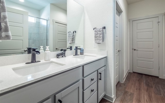 bathroom with wood-type flooring, vanity, and walk in shower