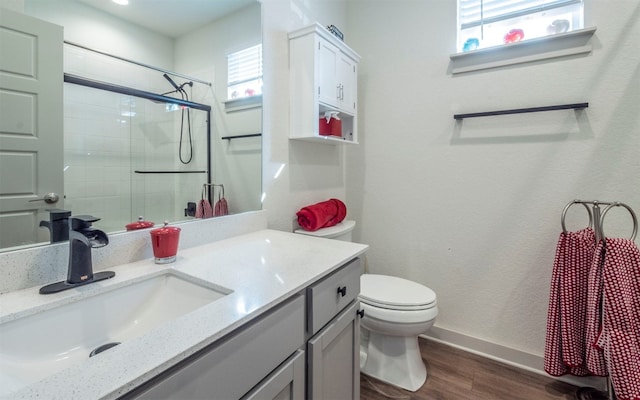 bathroom with vanity, toilet, an enclosed shower, and wood-type flooring