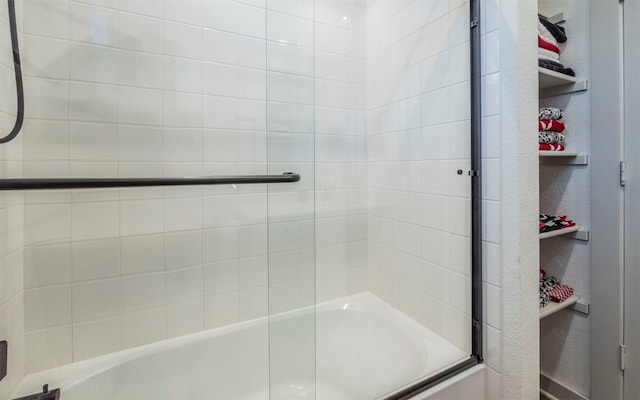 bathroom featuring bath / shower combo with glass door