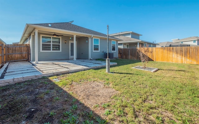 back of property with a yard and a patio