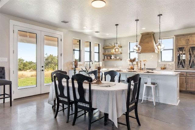 dining room featuring concrete flooring, visible vents, and a wealth of natural light