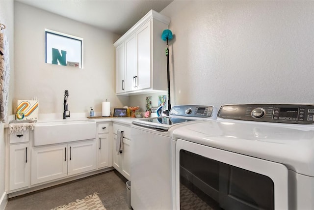 washroom featuring cabinet space, separate washer and dryer, and a sink