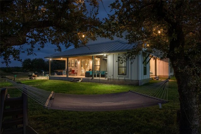 rear view of property with a yard, metal roof, and a deck