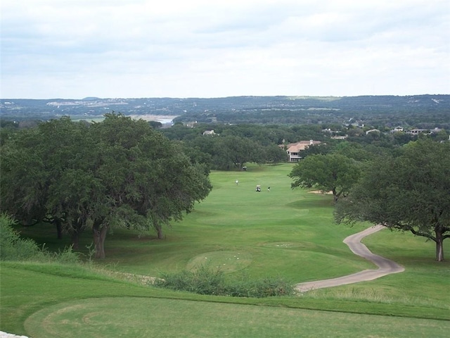 view of home's community featuring golf course view and a lawn