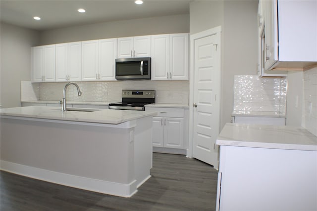 kitchen with sink, dark wood-type flooring, a kitchen island with sink, white cabinets, and appliances with stainless steel finishes