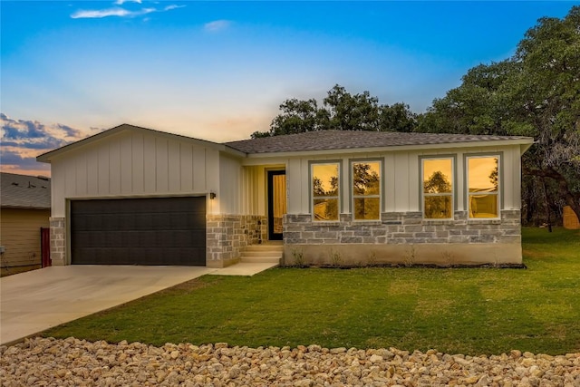 ranch-style home with a garage and a yard