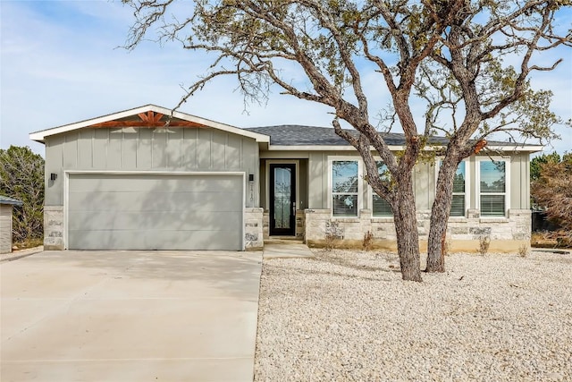 ranch-style home with a garage, stone siding, and board and batten siding