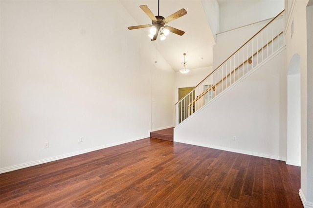 unfurnished living room with ceiling fan, dark wood-type flooring, and high vaulted ceiling