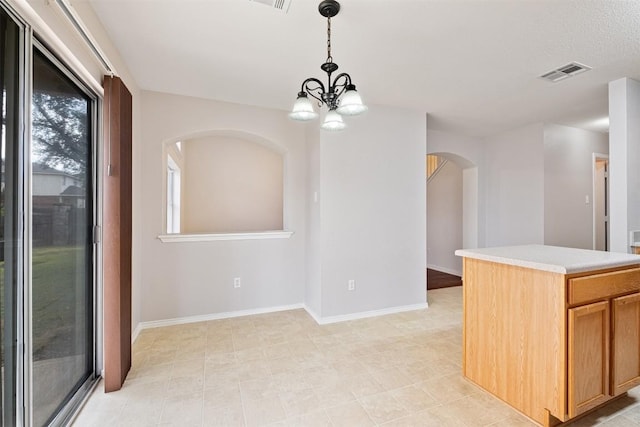 kitchen featuring plenty of natural light, hanging light fixtures, and a notable chandelier