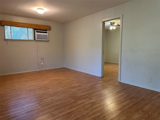 spare room featuring hardwood / wood-style floors, ceiling fan, and a wall mounted AC