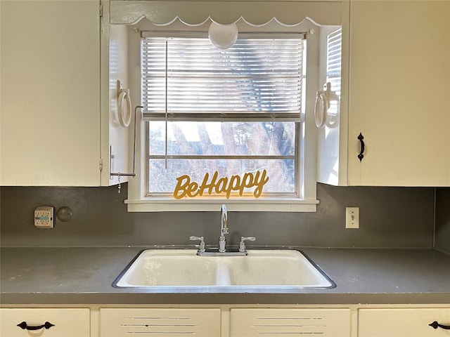 kitchen with white cabinets, backsplash, and sink