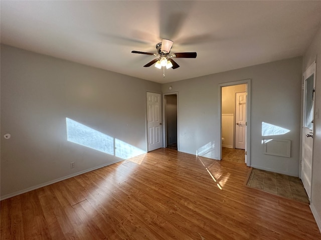 unfurnished bedroom with multiple windows, hardwood / wood-style floors, and ceiling fan