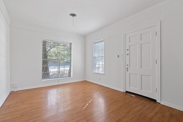 foyer entrance with wood-type flooring and crown molding