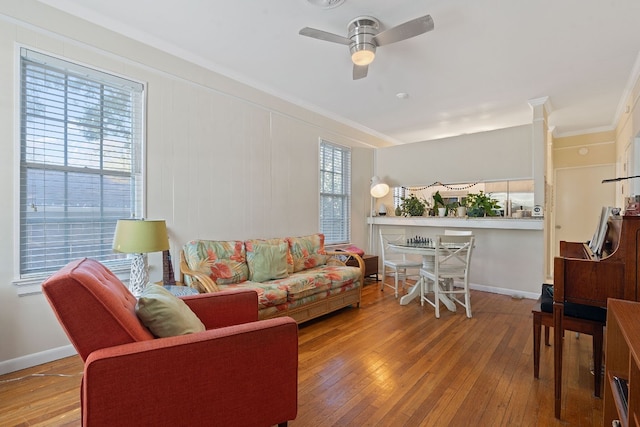 living room with hardwood / wood-style flooring, ceiling fan, and crown molding