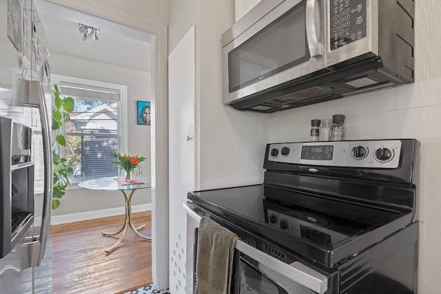 kitchen with stainless steel appliances and hardwood / wood-style flooring