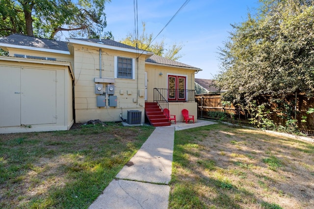 back of property featuring a yard and central AC unit