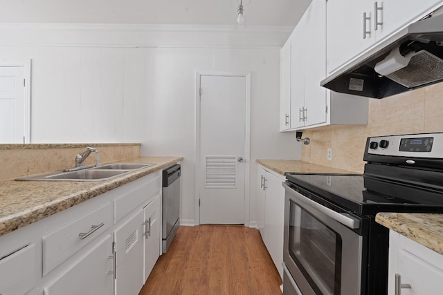 kitchen featuring white cabinets, sink, light hardwood / wood-style flooring, decorative backsplash, and appliances with stainless steel finishes