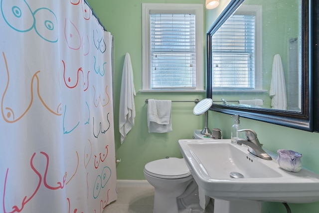 bathroom featuring tile patterned flooring, a shower with curtain, toilet, and sink