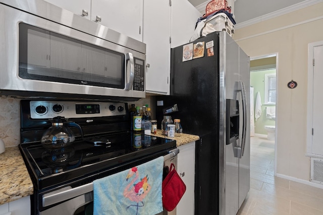 kitchen featuring ornamental molding, light tile patterned flooring, light stone counters, white cabinetry, and stainless steel appliances