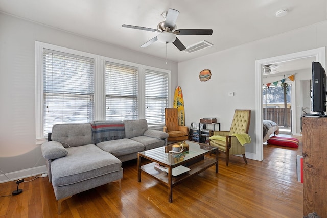 living room featuring plenty of natural light, ceiling fan, and wood-type flooring