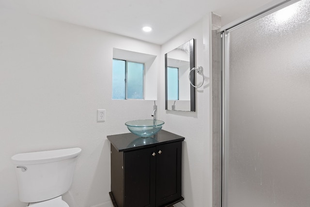 bathroom featuring vanity, toilet, and an enclosed shower