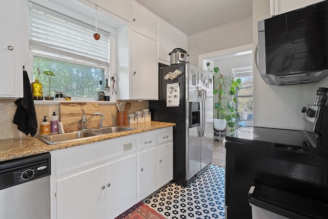 kitchen featuring appliances with stainless steel finishes, white cabinetry, a healthy amount of sunlight, and sink