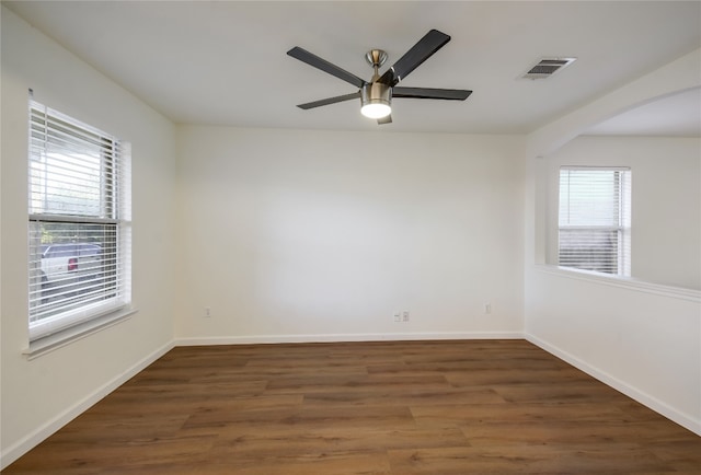 spare room featuring dark hardwood / wood-style floors, a healthy amount of sunlight, and ceiling fan