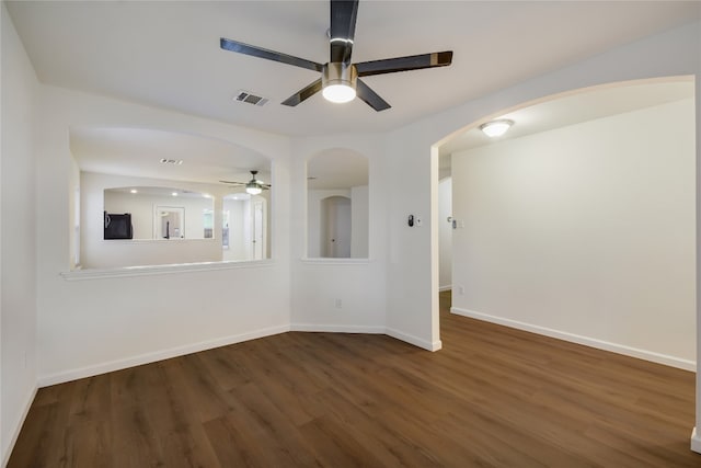 empty room with dark hardwood / wood-style floors and ceiling fan