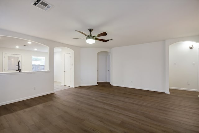 empty room featuring ceiling fan, dark hardwood / wood-style flooring, and sink