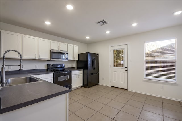 kitchen with light tile patterned flooring, sink, white cabinetry, and black appliances