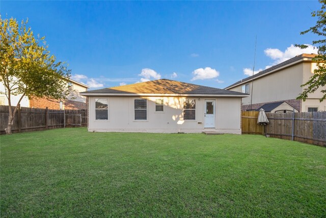 rear view of property with a lawn