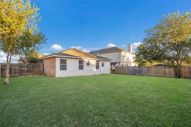 rear view of property featuring a lawn