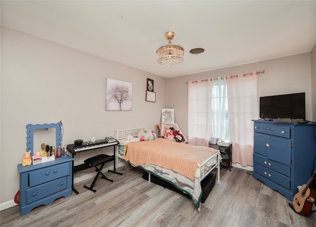 bedroom featuring a chandelier and light hardwood / wood-style flooring