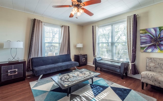 living room with dark wood-type flooring, crown molding, ceiling fan, and a healthy amount of sunlight