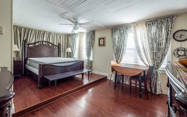 bedroom with ceiling fan, dark hardwood / wood-style flooring, and multiple windows