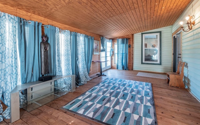 interior space featuring wood-type flooring, wood walls, lofted ceiling, and wood ceiling