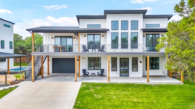 modern home featuring a garage, a balcony, and a front yard