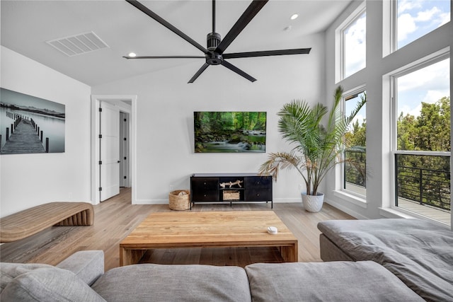 living room featuring hardwood / wood-style floors, high vaulted ceiling, and ceiling fan