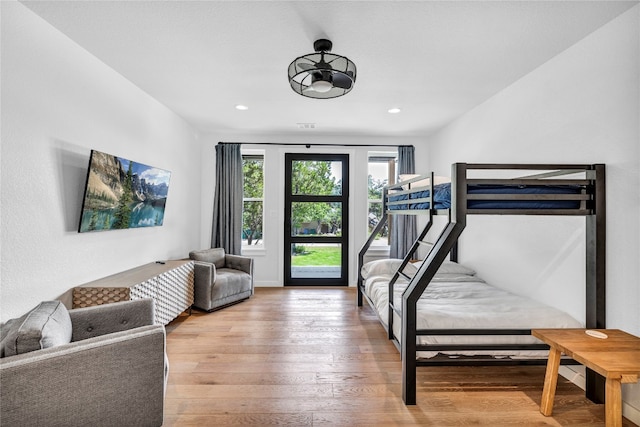 bedroom featuring wood-type flooring and access to outside