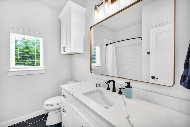 bathroom with tile patterned floors, toilet, vanity, and walk in shower