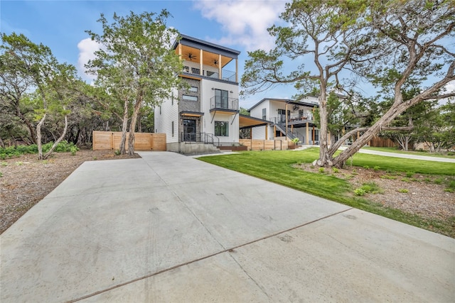 view of front of home featuring a balcony and a front lawn