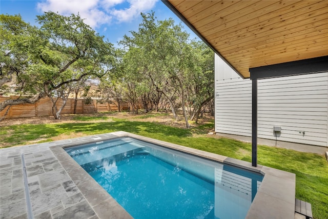 view of swimming pool featuring a yard