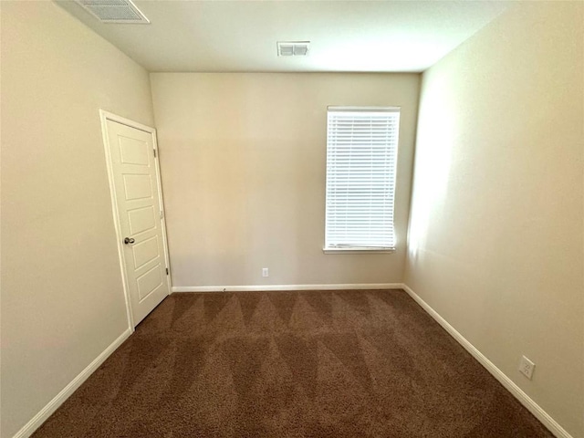 empty room with dark carpet and baseboards