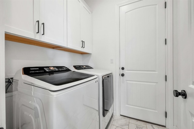 laundry area featuring washer and clothes dryer and cabinets