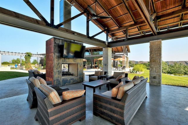 view of patio / terrace with an outdoor living space with a fireplace and ceiling fan